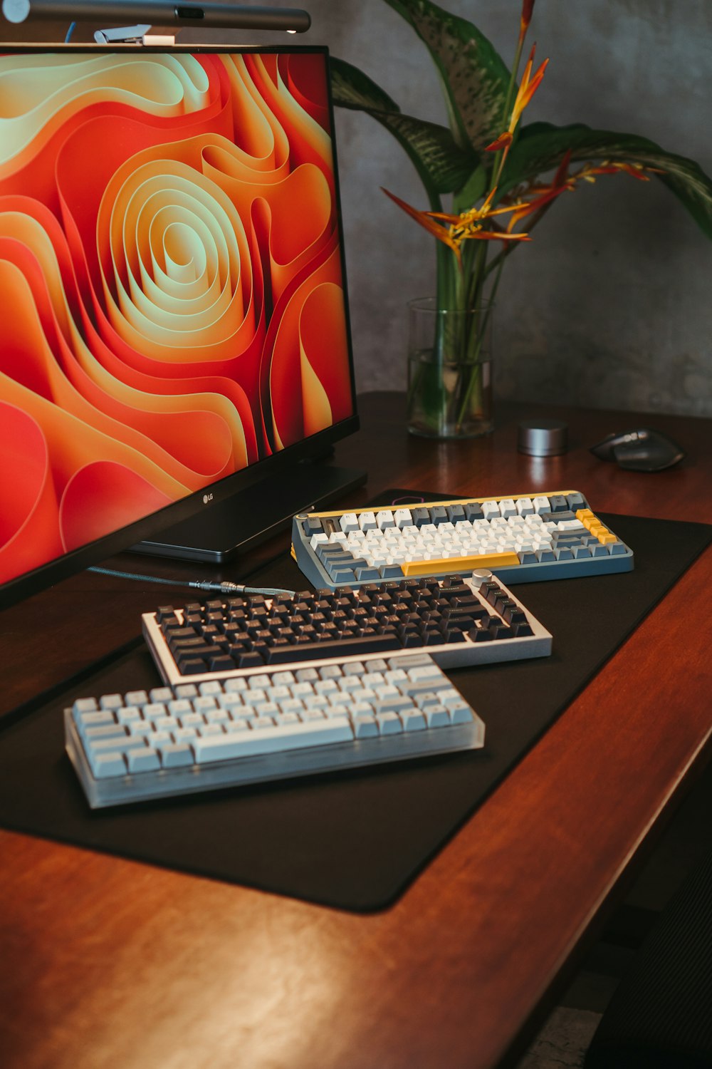 a vase of flowers sits on a desk next to a computer