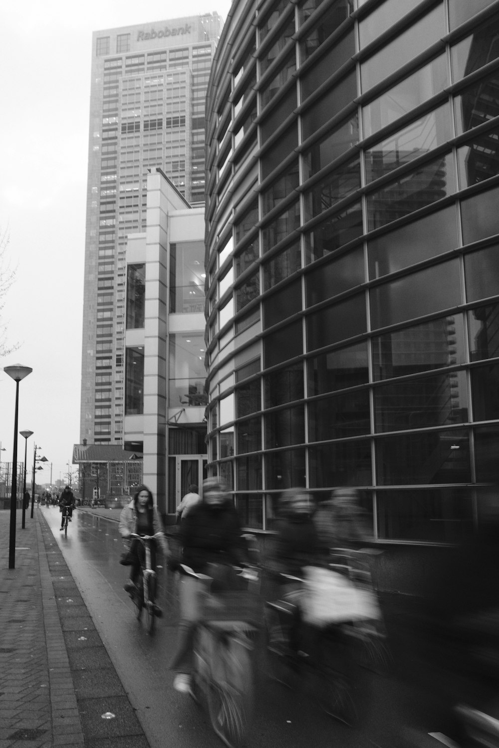 a group of people riding bikes on a street between buildings