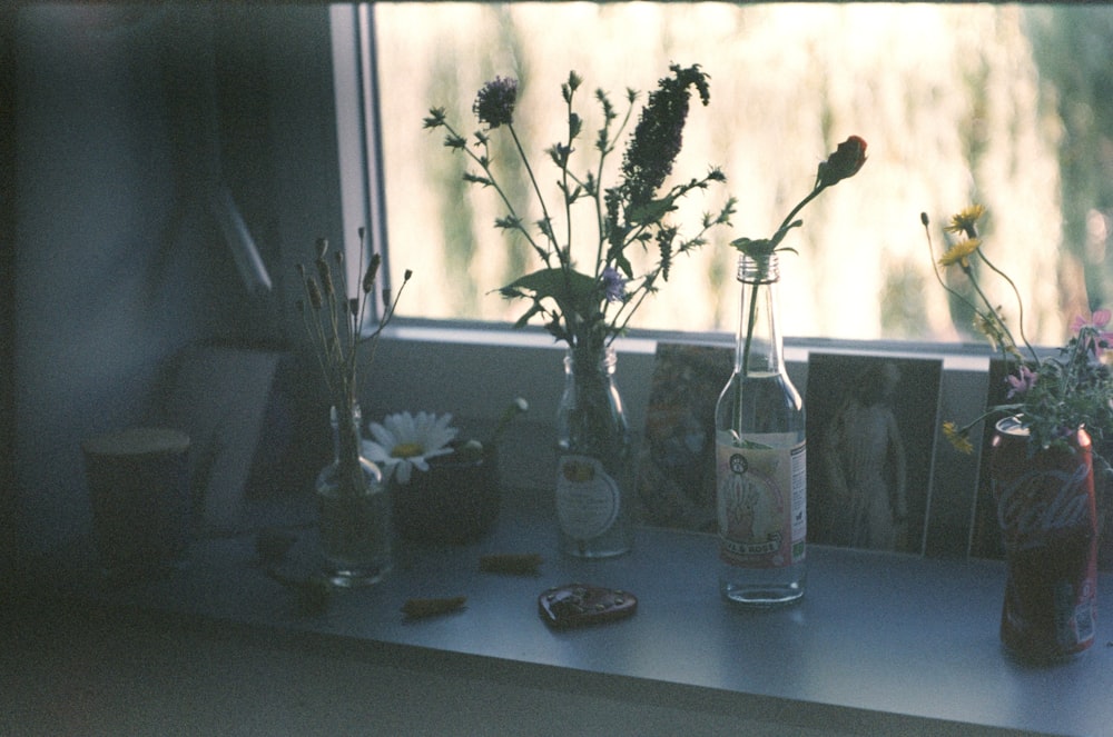 a group of glass vases with flowers in them