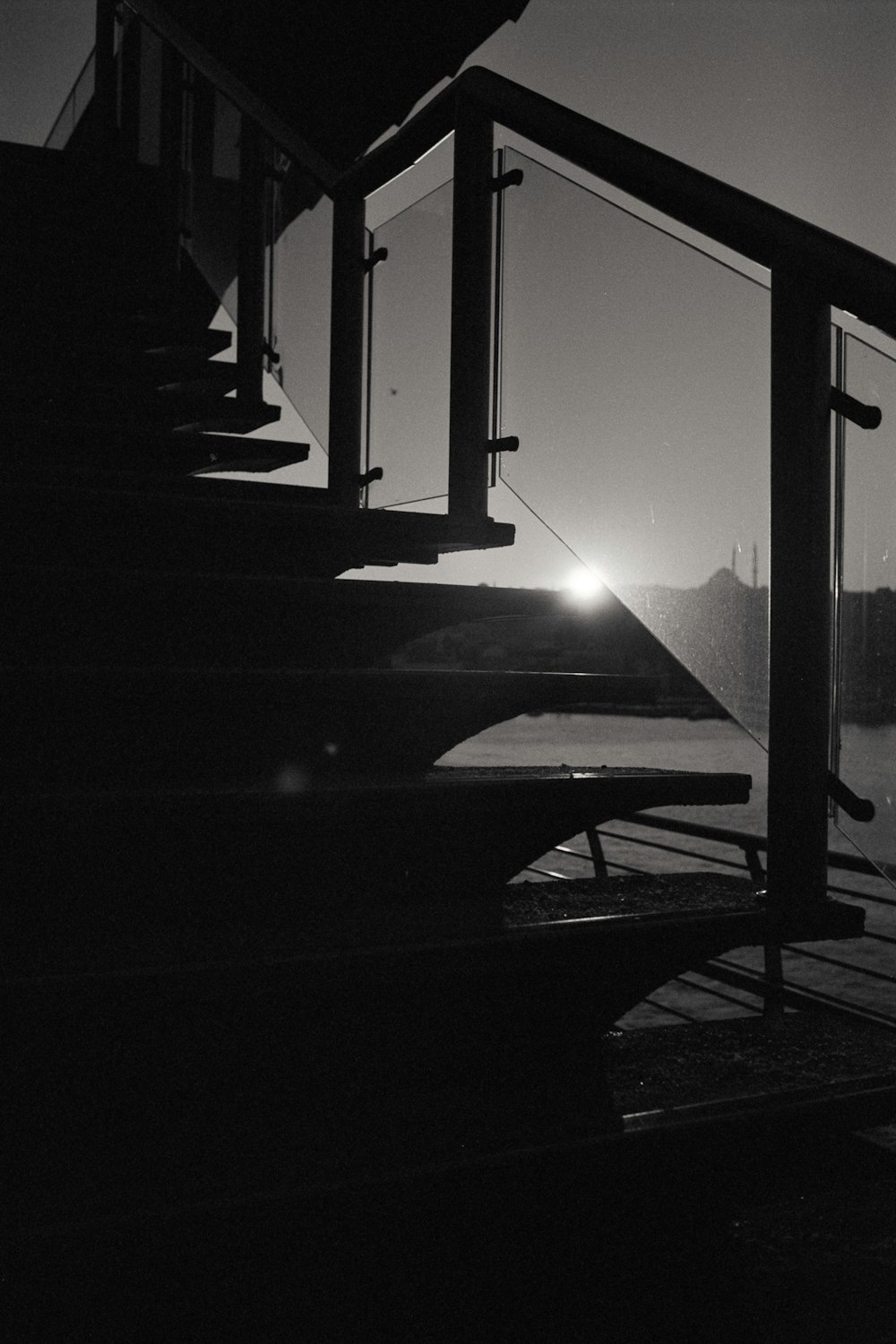 a black and white photo of a bridge with a light on it