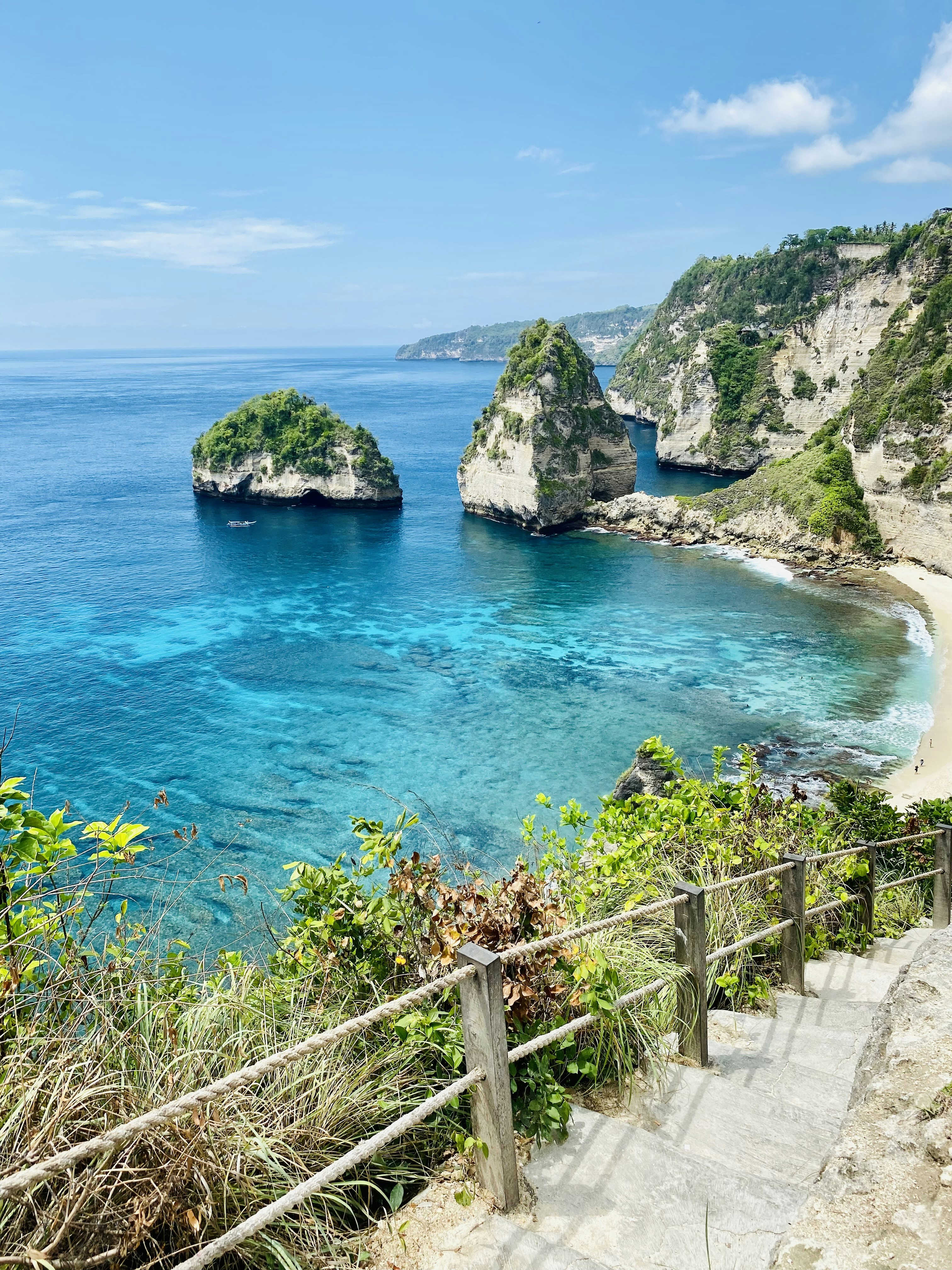 a path leading to a beach with Isola Bella in the background