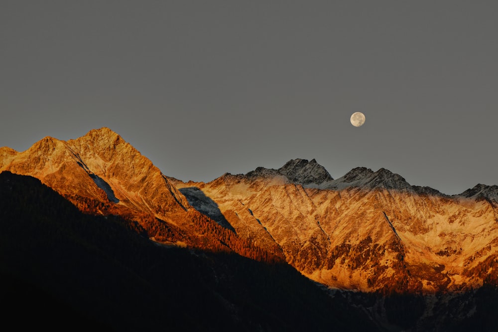 a mountain with a moon in the sky