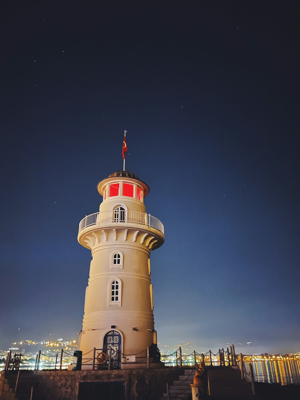 a white tower with a flag on top