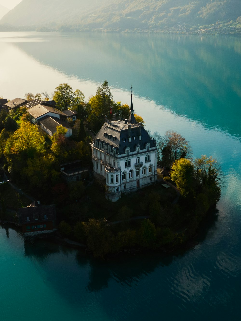 a building on a hill by a body of water