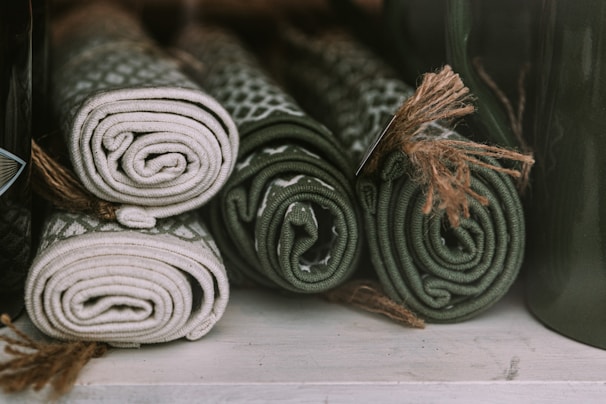 Stack of rolled-up eco-friendly rugs made from straw and recycled fibers