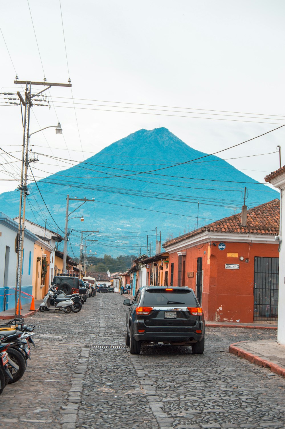 a car parked in front of a building with a blue tarp