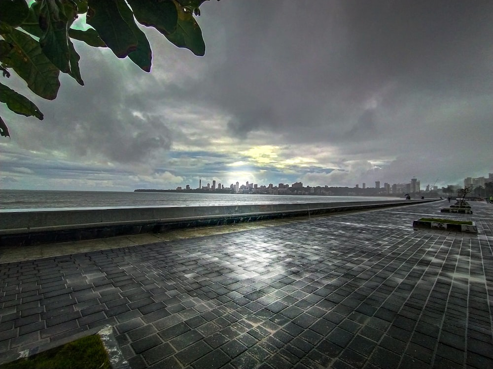 a stone walkway with a boat on it and a cloudy sky