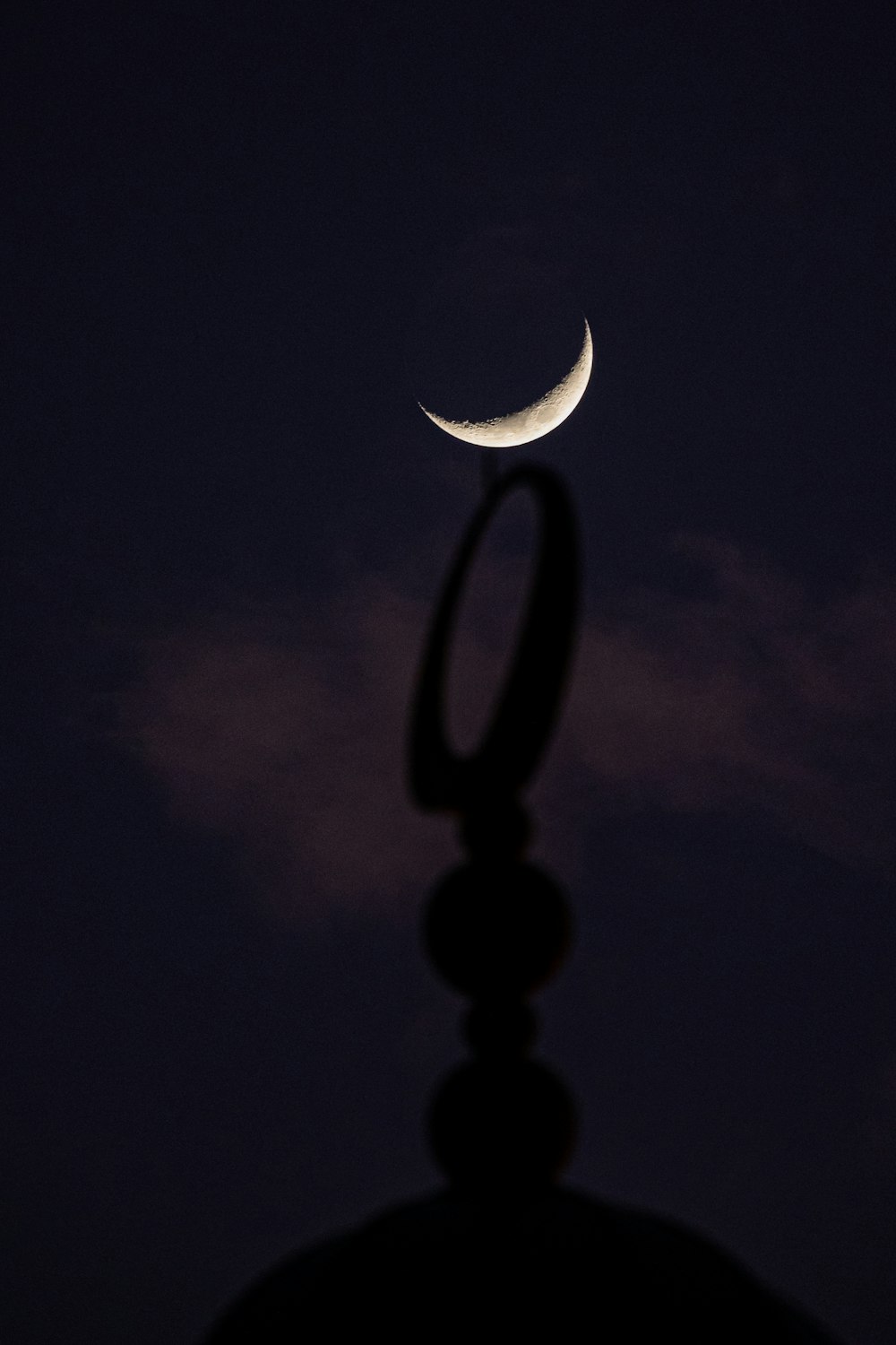 a silhouette of a person with a crescent moon in the sky
