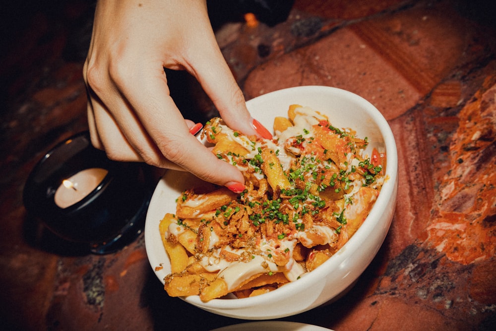 a hand holding a plate of food