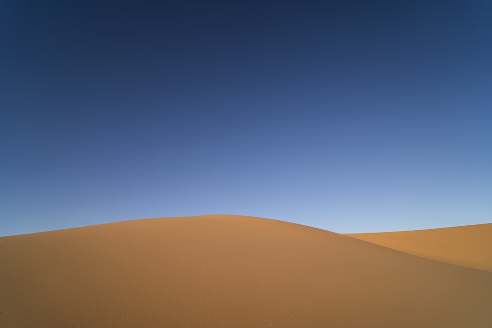 a sand dune under a blue sky