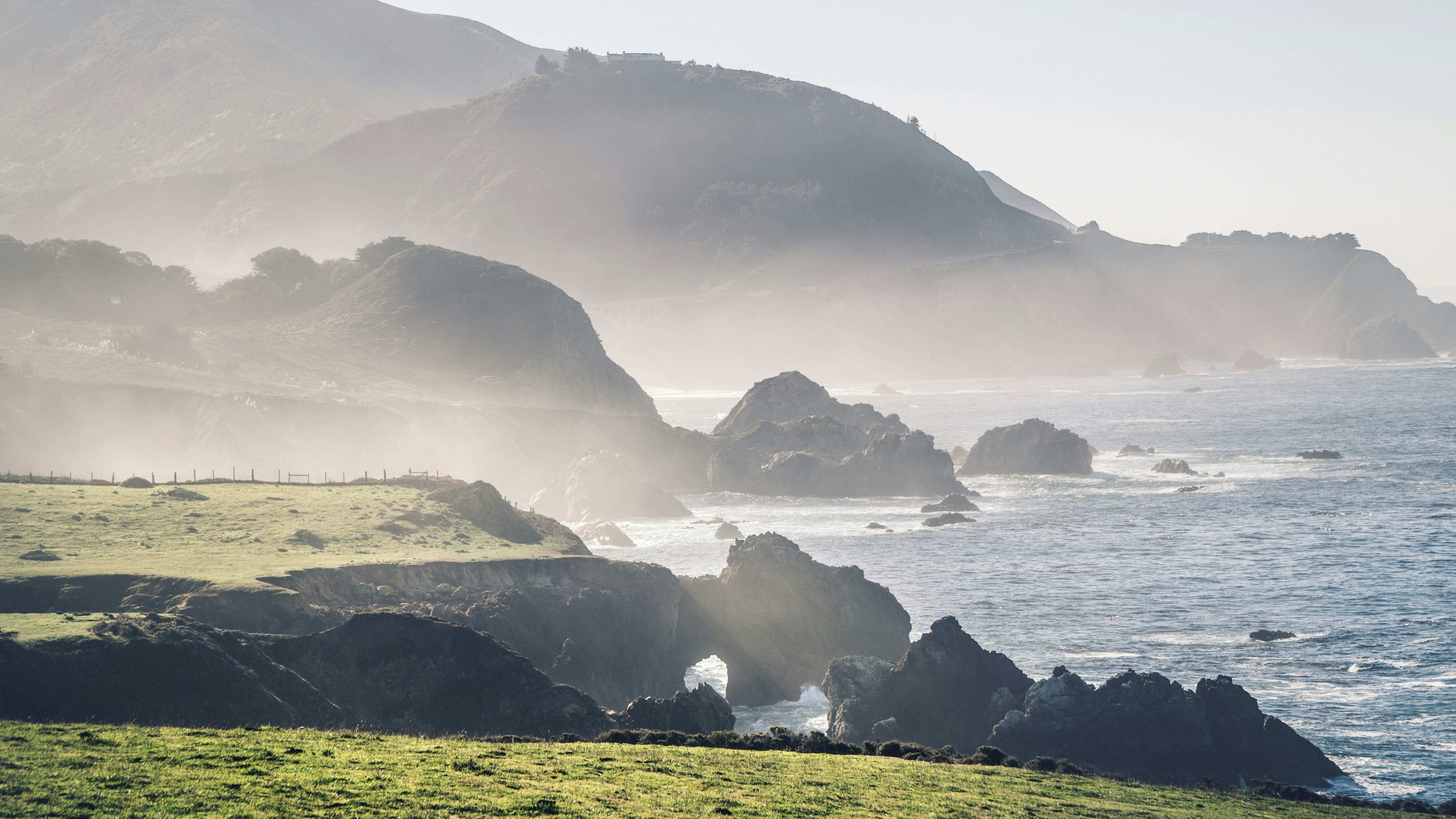 a body of water with cliffs and grass around it