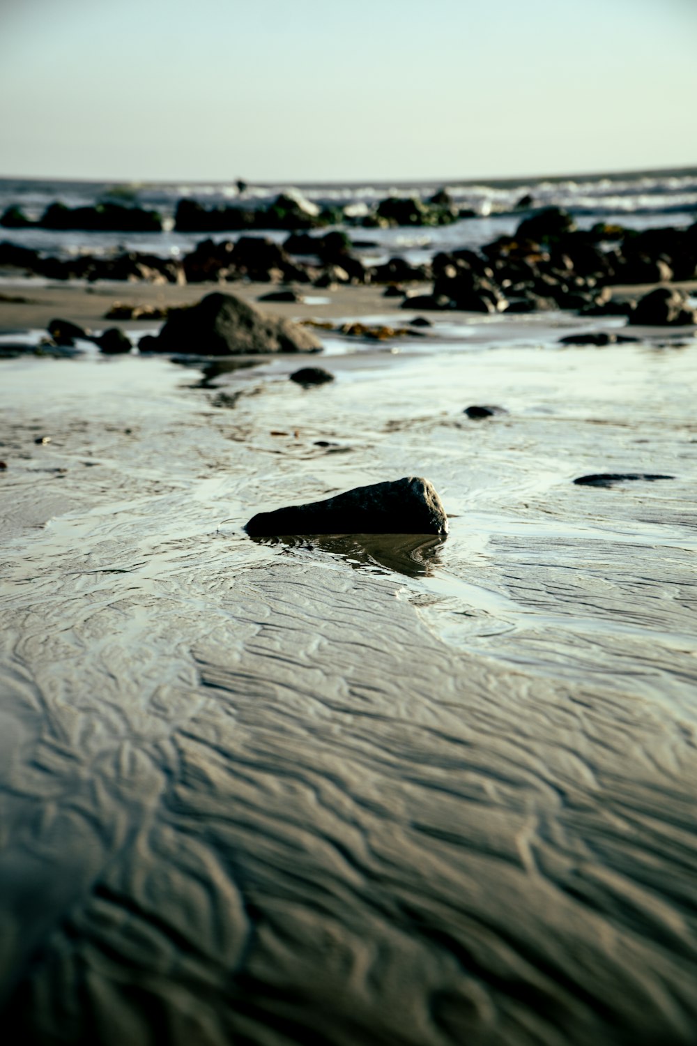 a rocky beach with a large body of water in the background