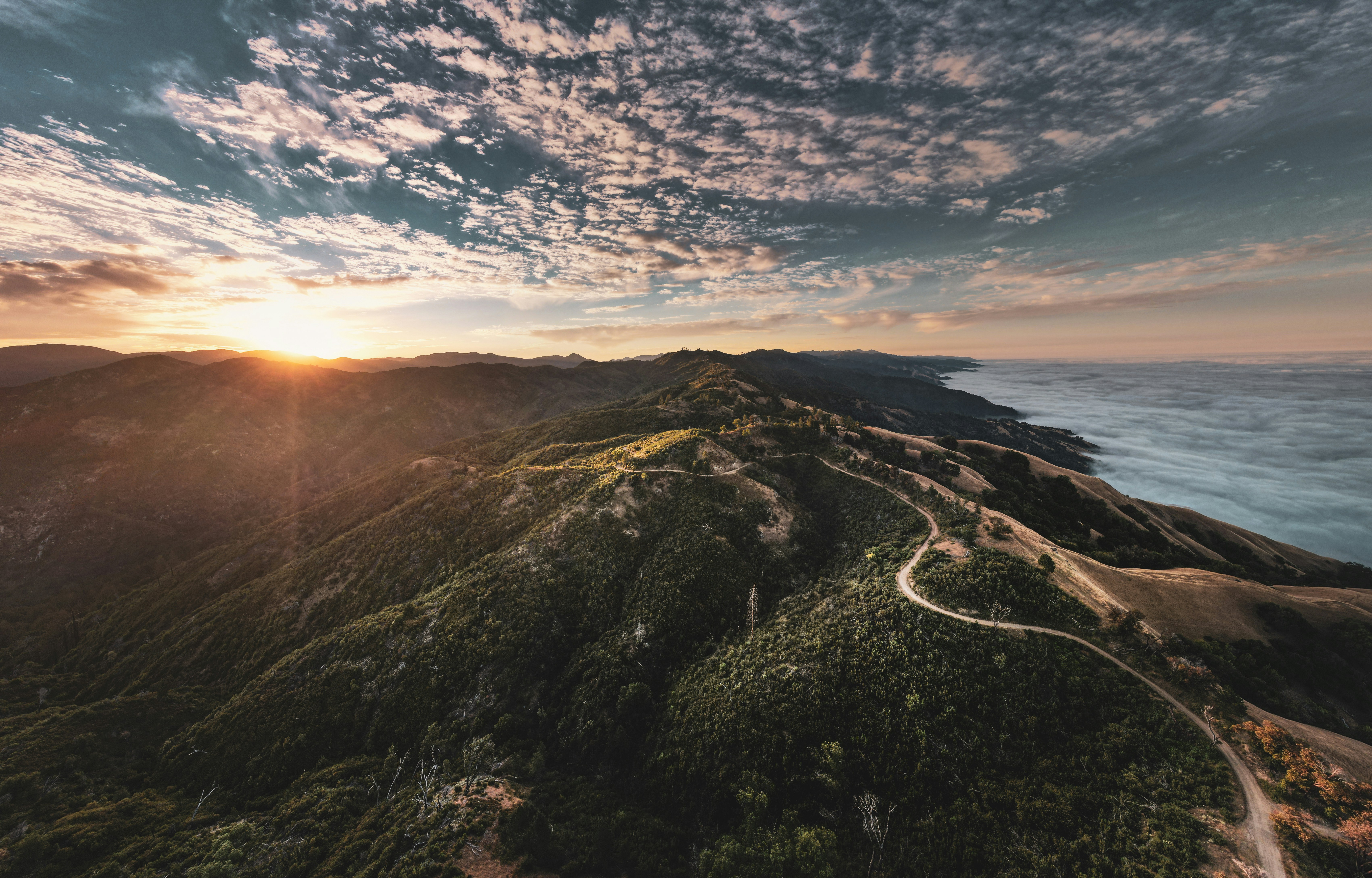 a mountain with a road and a sunset