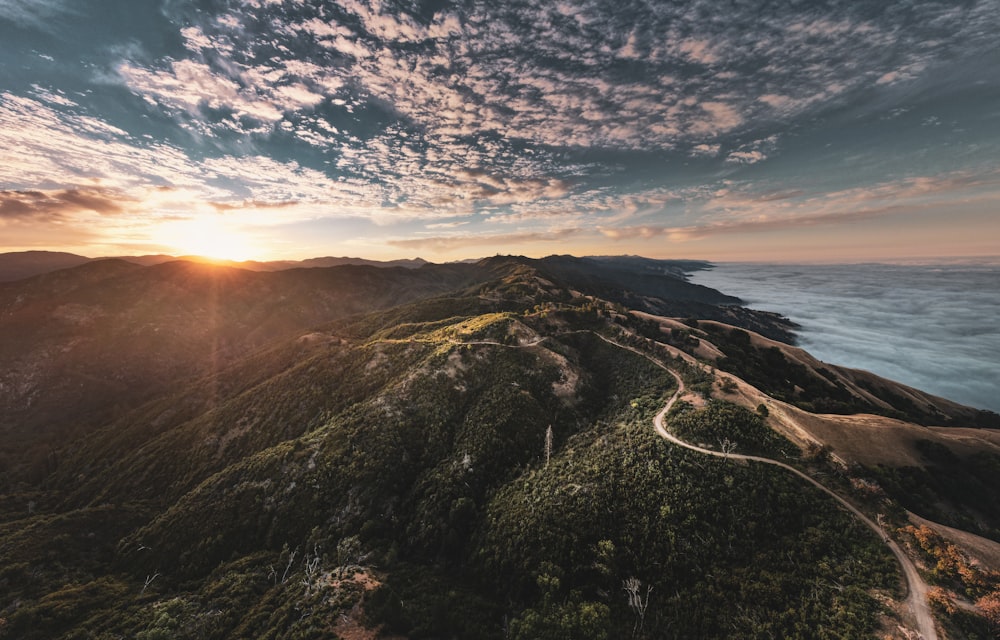 a mountain with a road and a sunset