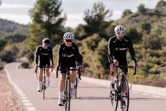 Um grupo de ciclistas junto a uma árvore