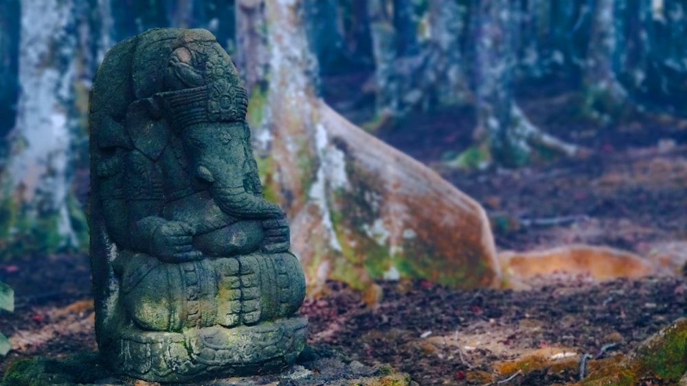 Una estatua de una persona con una calavera y un árbol en el fondo