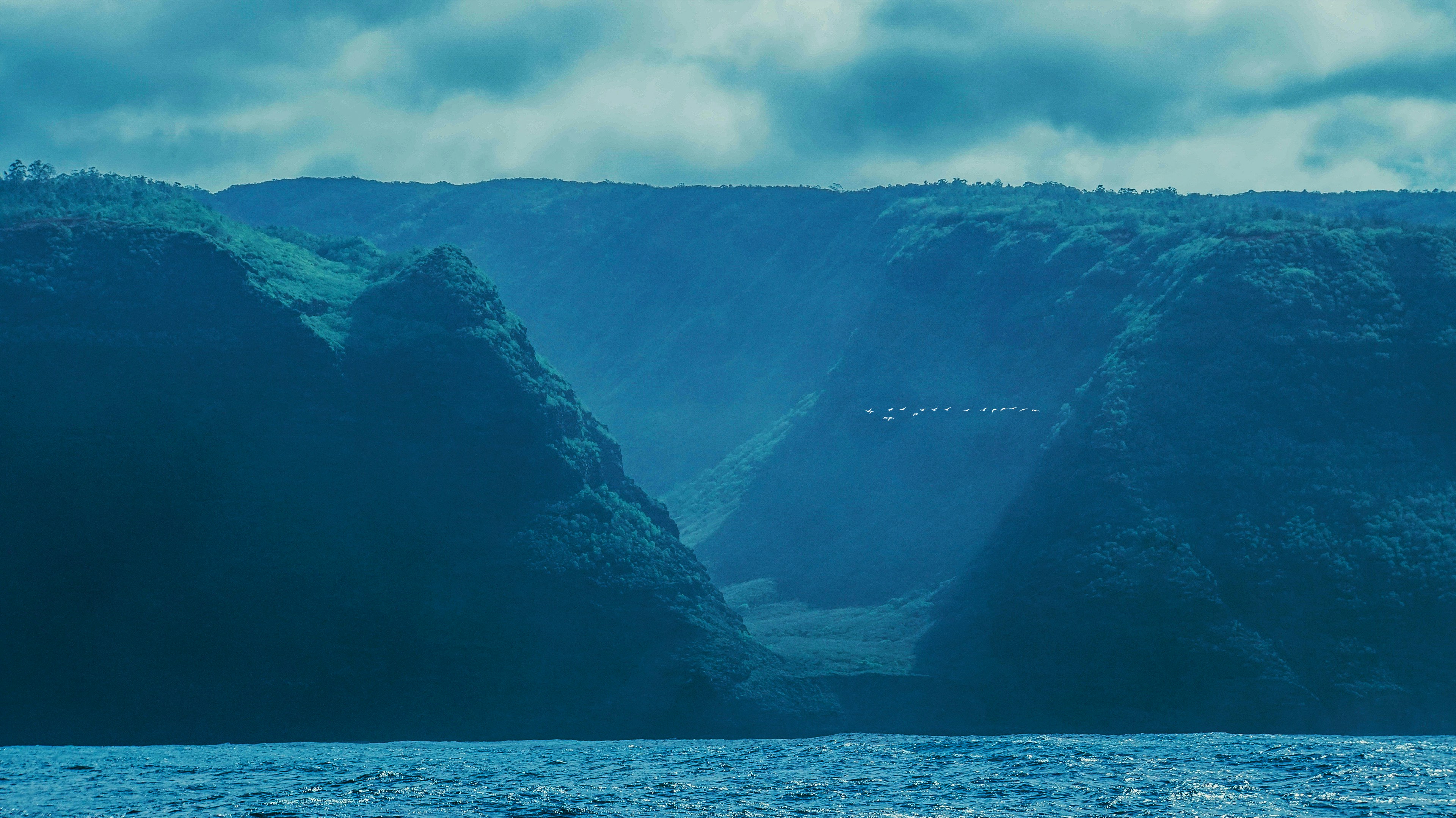 a large body of water with mountains in the background