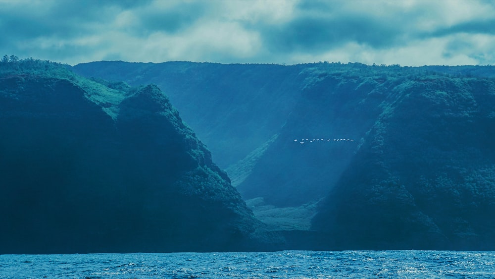 a large body of water with mountains in the background