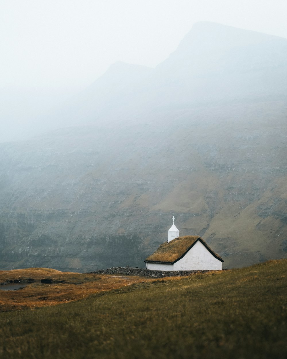 a small white building on a hill