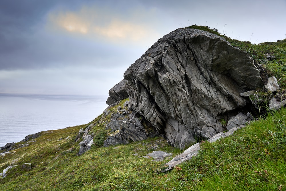 a large rock on a grassy hill