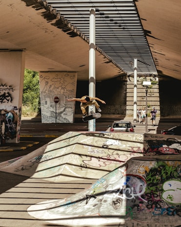 A group of diverse skateboarders performing tricks in an urban skate park.