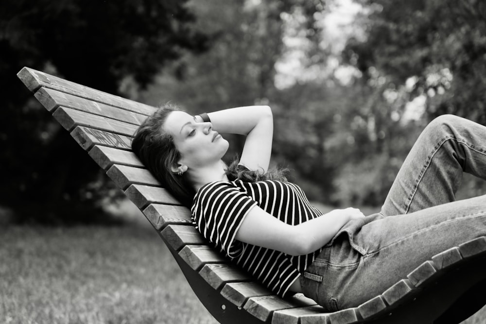 a woman lying on a bench