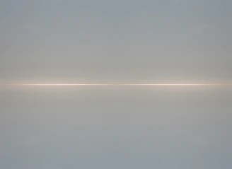 Minimalist horizon with soft light rays breaking through a deep navy sky.