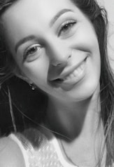 Close-up of Maria smiling warmly during a casual on-set moment.