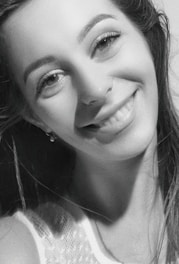 Portrait of Yvanca, a warm and approachable woman in her 40s, smiling gently in a bright, modern room.