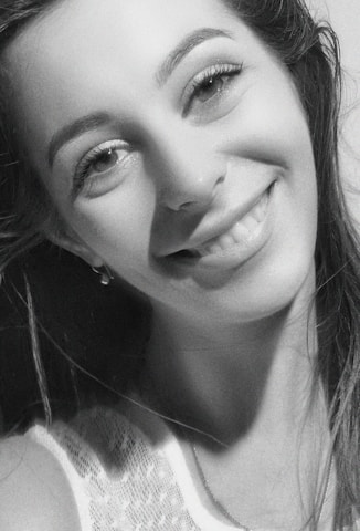 Portrait of Yvanca, a warm and approachable woman in her 40s, smiling gently in a bright, modern room.