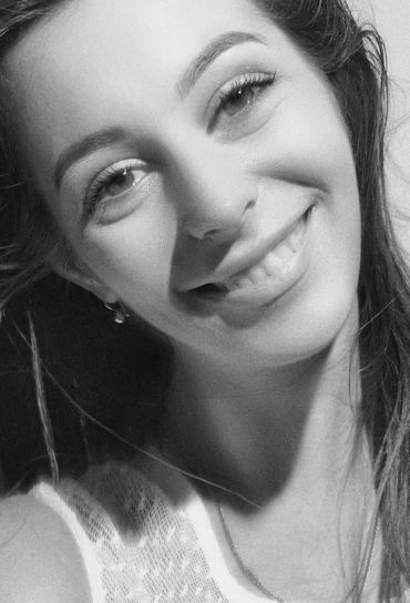 A striking black-and-white portrait of a bride laughing softly in natural light.