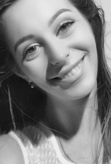 Portrait of Thainara Maria warmly smiling in her beauty studio.