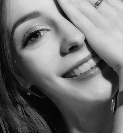 A joyful woman wearing a handcrafted semi-jewel ring, smiling naturally