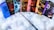A collection of seven books from the Harry Potter series is displayed on a fluffy white surface. Each book has a colorful and distinct cover design. A wand is placed in front of the books, creating a magical theme.