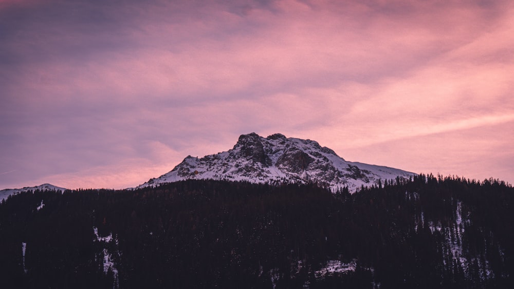 Una montagna innevata con un cielo viola