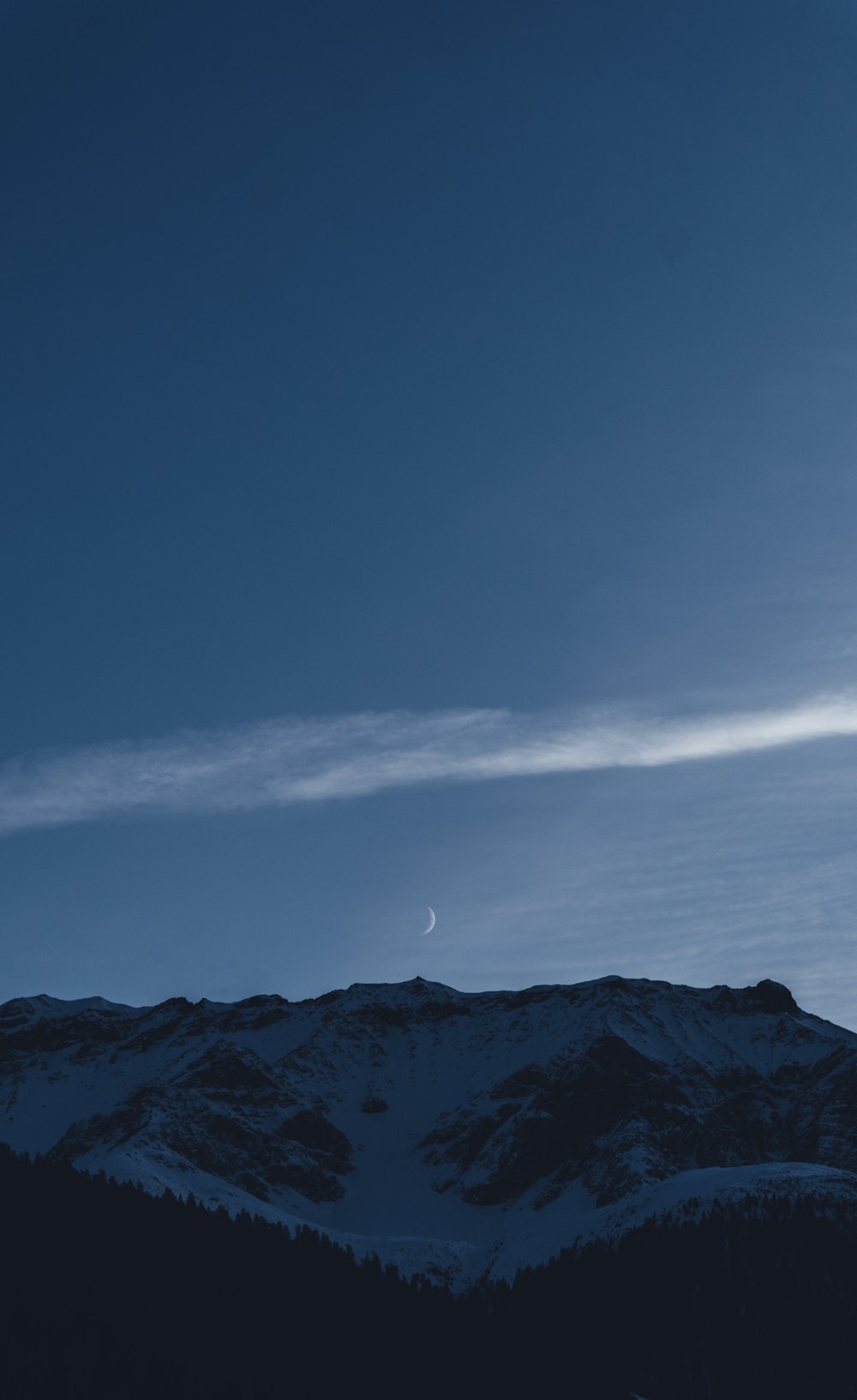 Una montagna con una nuvola nel cielo