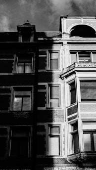 Black and white photo of an urban heritage building facade with deep shadows and high contrast.
