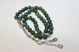 A collection of elegant prayer beads made from rare stones laid out on a velvet cloth highlighting their polished finish.