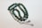 A strand of prayer beads with polished green stones, intricately designed silver separators, and decorative metallic tassels.