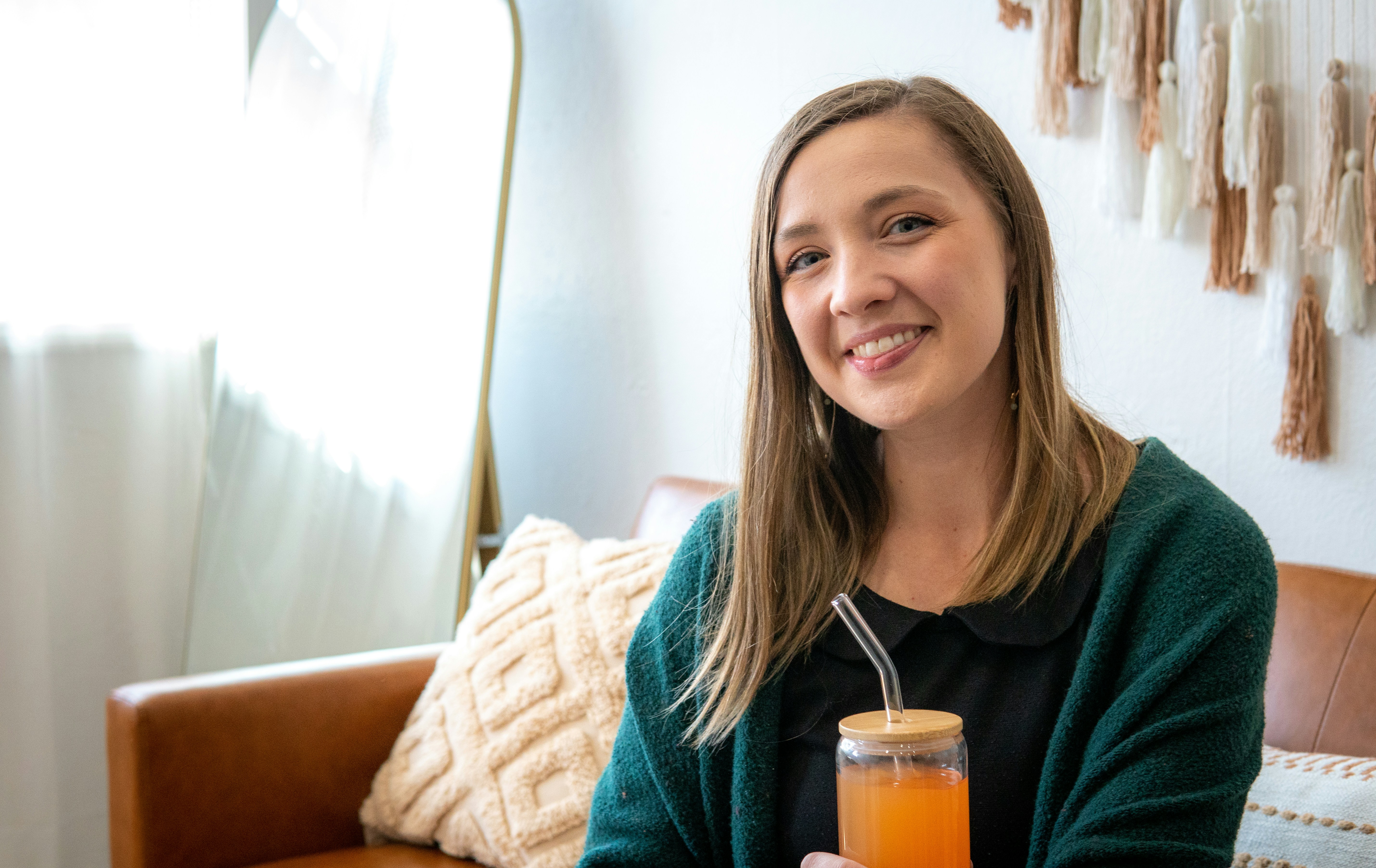 a woman holding a glass of orange juice