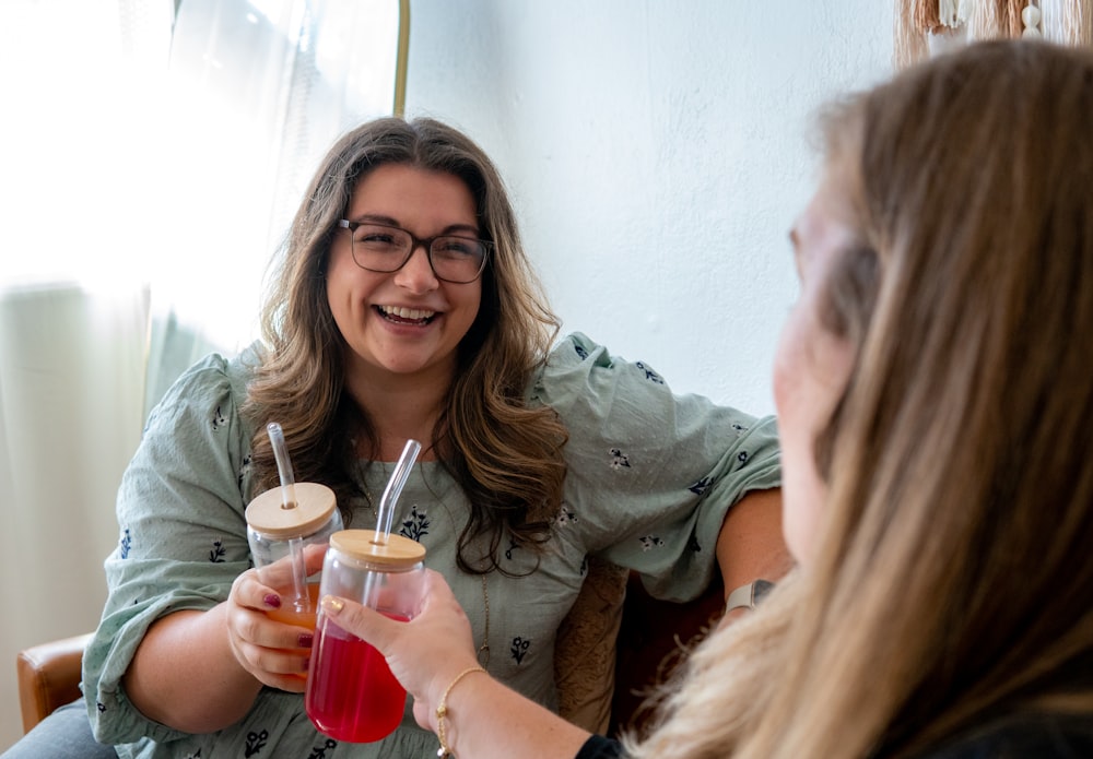 a woman holding a drink and a woman holding a glass with a straw