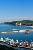 A serene view of the coastline with fishermen preparing their boats at dawn.