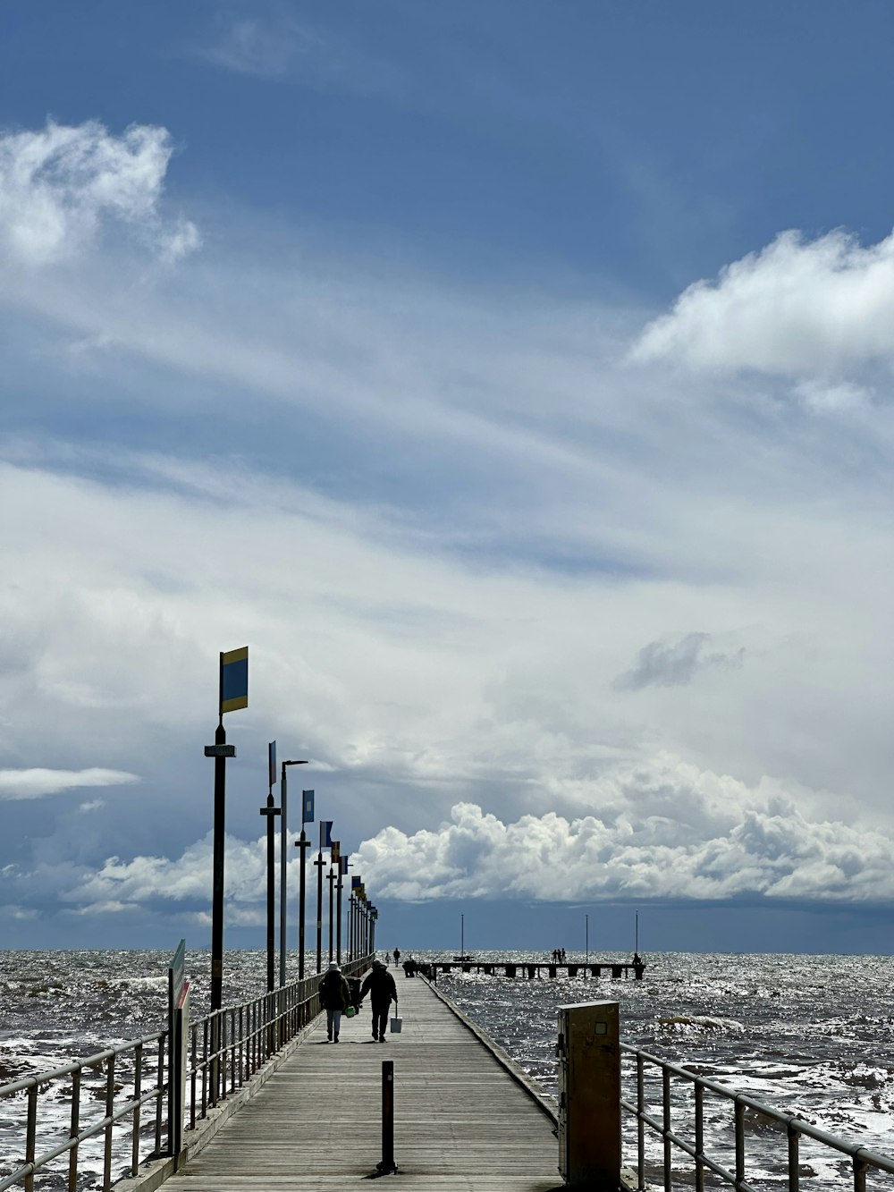 a couple people walking on a boardwalk