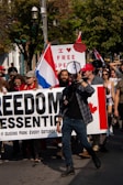 A close-up of a protest sign reading 'Freedom of Speech or Hate?'.