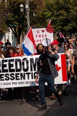 A close-up of a protest sign reading 'Freedom of Speech or Hate?'.
