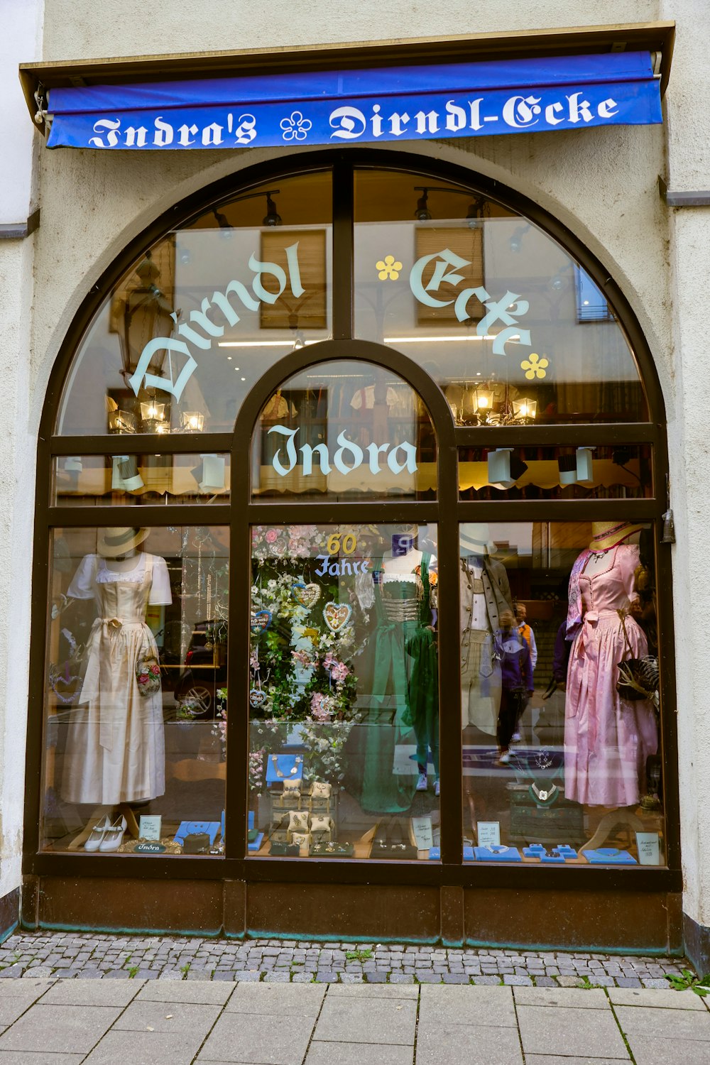 uma frente de loja com manequins na janela