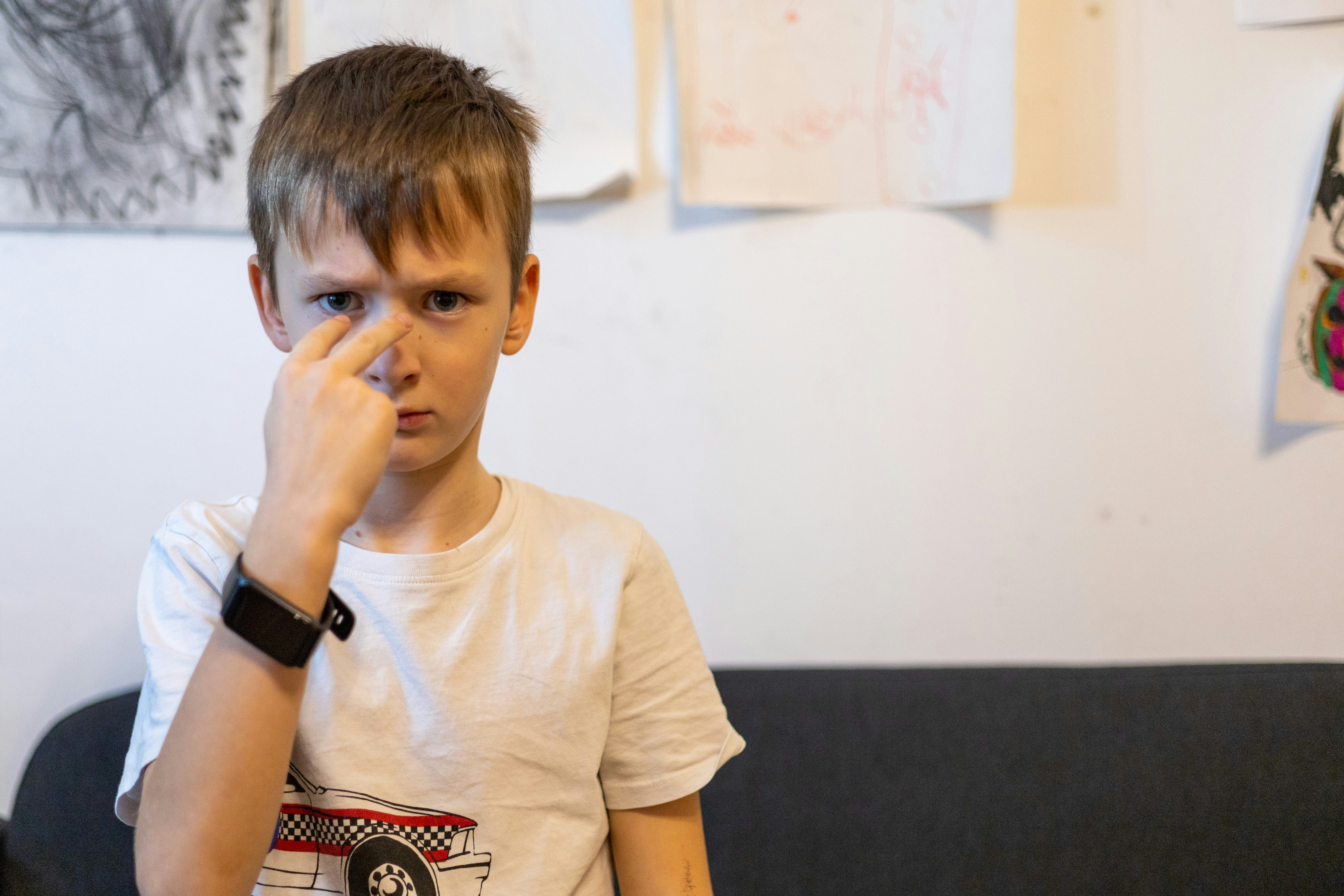 a boy with his hand on his face