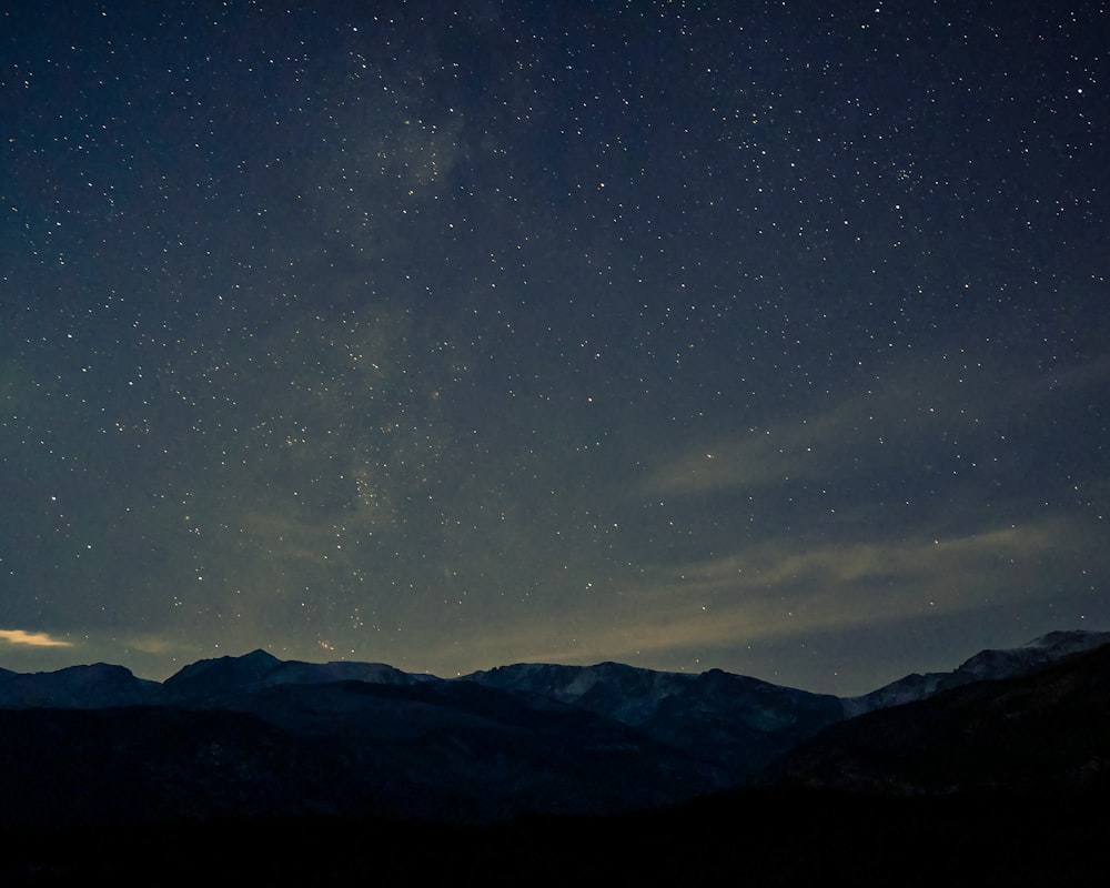 a starry night sky over mountains