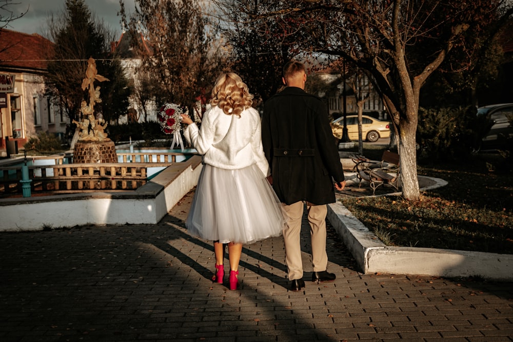 a man and woman walking down a sidewalk