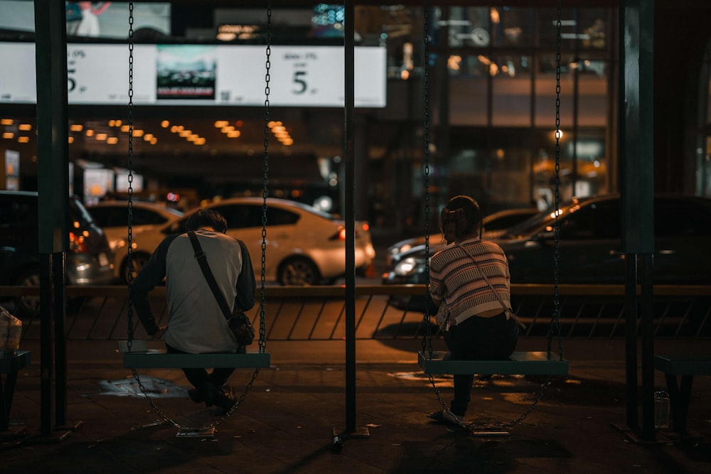 a couple of people sit on a bench